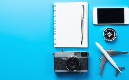 Travel blogger accessories with copy space on blue backgroundの写真素材