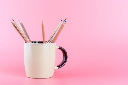 Color Pencil in coffee mug on pink background with copy spaceの写真素材