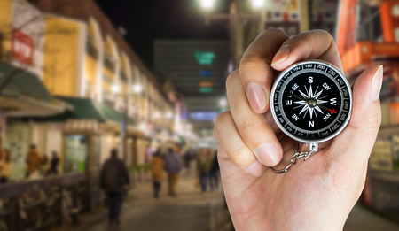 Hand holding compass for direction in fukuoka japanの写真素材