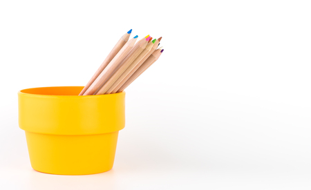 Multicolor pencils in orange bucket isolated on whiteの写真素材