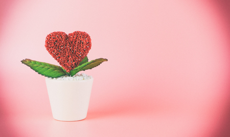 Red Valentines heart pot on pink copy spaceの写真素材
