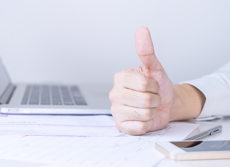 Thumb up sign from business success in officeの写真素材