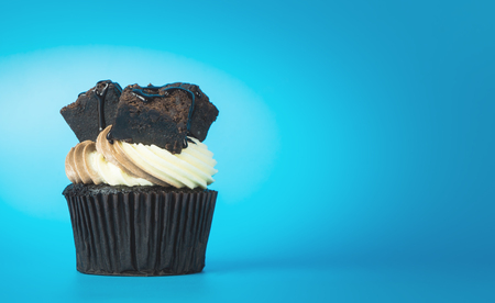Chocolate brownie cupcake on blue copy space backgroundの写真素材