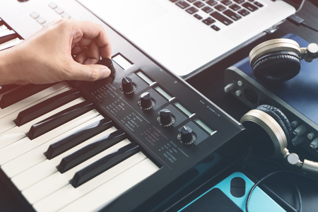 Musician is adjusting sound on synthesizer keyboardの写真素材