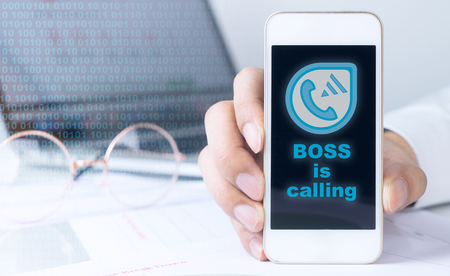 Boss is calling on office worker mobile phoneの写真素材