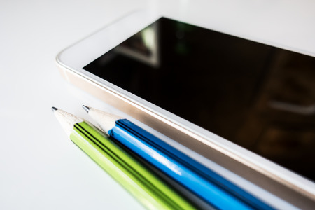 Smart phone with sharp epncil on white tableの写真素材
