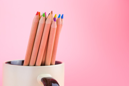 Color pencils in mug on pink background copy spaceの写真素材