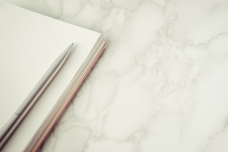 Metal pen on a blank notebook page with marble copy spaceの写真素材