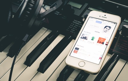 Tokyo, Japan - May 1, 2017: Musician is using iTunes Music on phone to listen to music.のeditorial素材