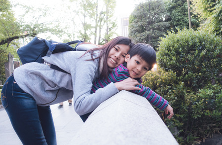 Asian mother is Holding her son on a rock bridge with love and funの写真素材