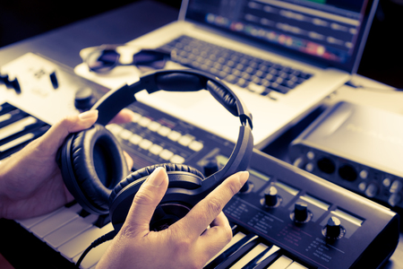 Sound Engineer is picking headphone to start mixing song.の写真素材