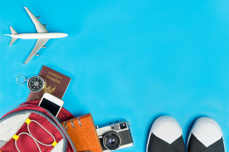 Backpacker travel accessories with toy plane on blue backgroundの写真素材