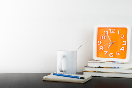 Education desktop with coffee and orange clockの写真素材