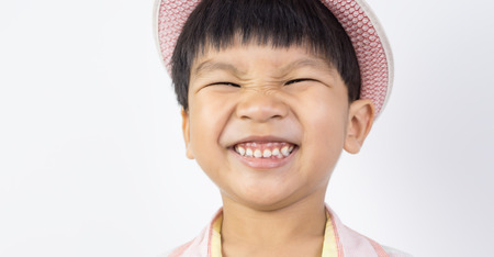 Asian boy happily smiling with his eyes closedの写真素材