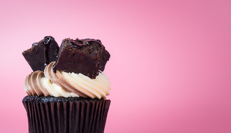 Chocolate brownie cupcake muffin on pink backgroundの写真素材