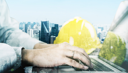 Engineer working with computer with City double exposureの写真素材