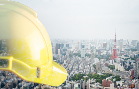 Construction Helmet with City double exposure on backgroundの写真素材