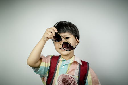 Backpacker boy traveler is putting on sunglassesの写真素材