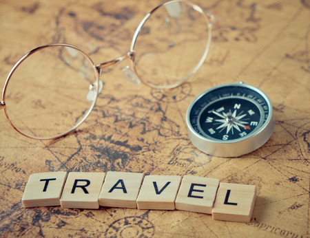 Travel text with vintage compass and glasses on mapの写真素材