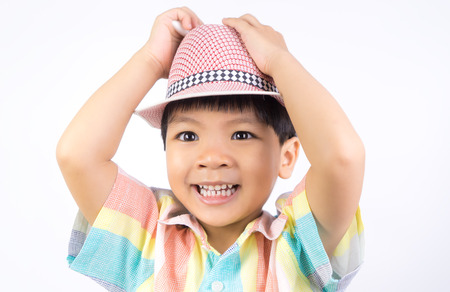 Traveler boy putting on his hat isolated on whiteの写真素材
