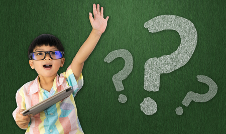 boy holding tablet raise his hand to ask questionの写真素材