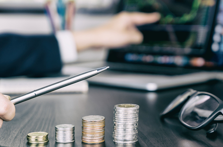 Stock trader pointing pen up as his money profit growing upの写真素材