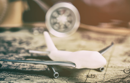 Airplane with compass on vintage map for travel explorer conceptの写真素材