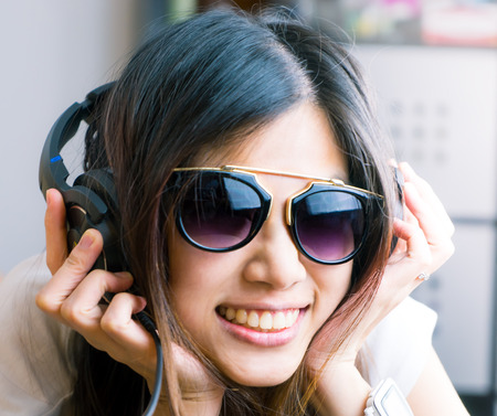 Asian girl with eyeglasses is listen to music on headphoneの写真素材