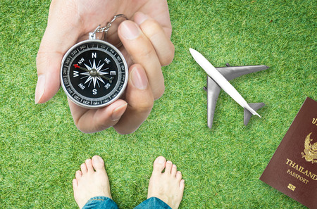 Holding Compass for nature travel direction with bare feetの写真素材