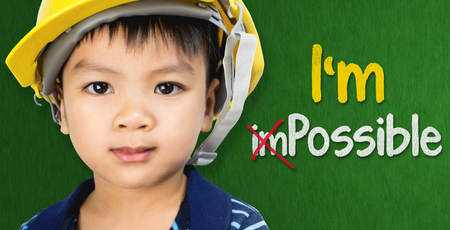 Boy wearing engineering hat with Im possible text for Educational and occupation possibility conceptの写真素材