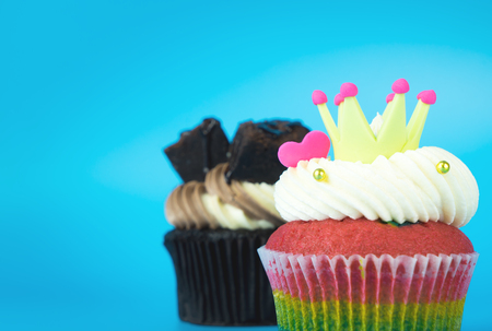 King Cupcake Rainbow muffin with Chocolate brownie cupcake on blue backgroundの写真素材