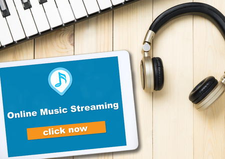 Online Music streaming button on tablet screen with music accessoriesの写真素材