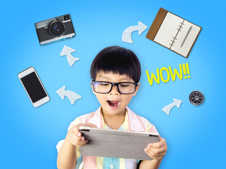 Nerdy kid is excited by tablet abilities and functionの写真素材