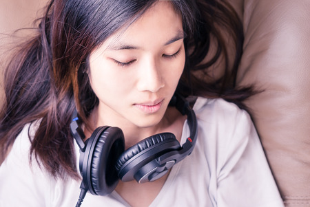 Chinese lady is sleeping with headphone on sodaの写真素材