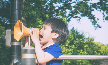 Boy is screaming out into playground Megaphoneの写真素材
