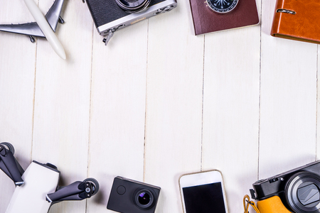Travel accessories and gadgets with white wooden copy space in the middleの写真素材