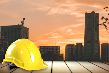 Engineer safety helmet on wooden counter with city backgroundの写真素材