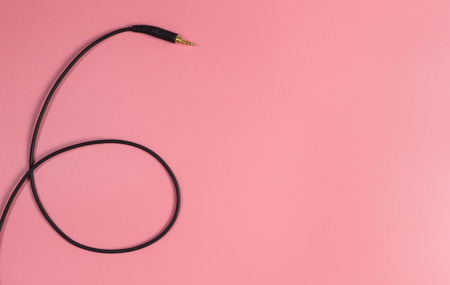 Black headphone jack on pink copy spaceの写真素材