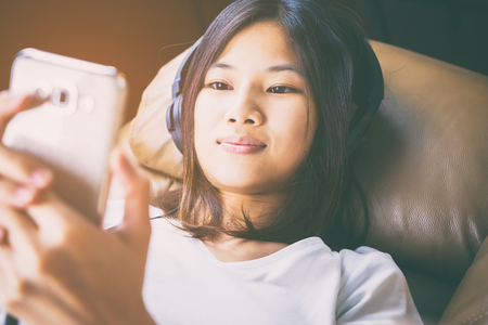 Asian women is listen to music on her mobile phoneの写真素材