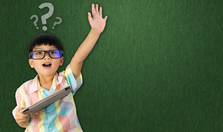 boy holding tablet raise his hand up for question askingの写真素材