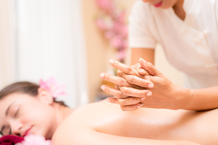 Spa Therapist is massaging women back with her elbow.の写真素材