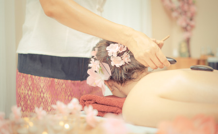 Spa Therapist is placing Hot stone on a Women backの写真素材