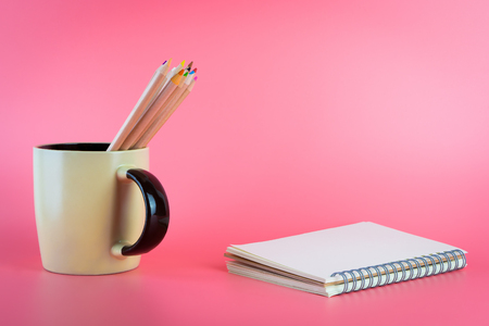 Color pencils in coffee mug with scrapbook for art conceptの写真素材