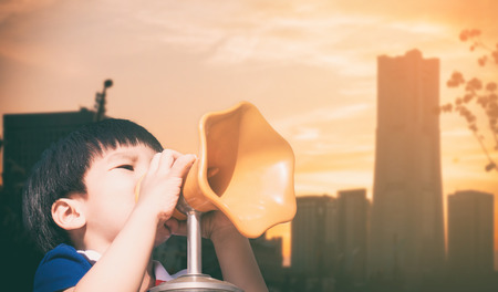 Boy screaming out megaphone in the cityの写真素材