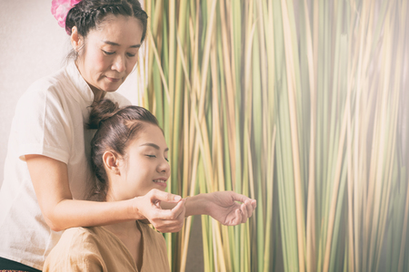 Women is getting shoulder massage from Thai therapistの写真素材
