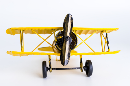 Vintage yellow metal toy airplane on white backgroundの写真素材