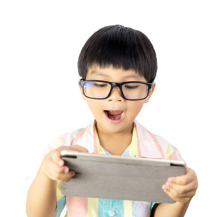 Nerdy Asian boy is surprising on the tablet isolated on whiteの写真素材