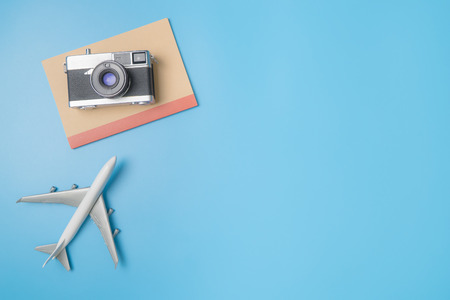 Plane and camera notebook for travel blogger concept copy space on blueの写真素材