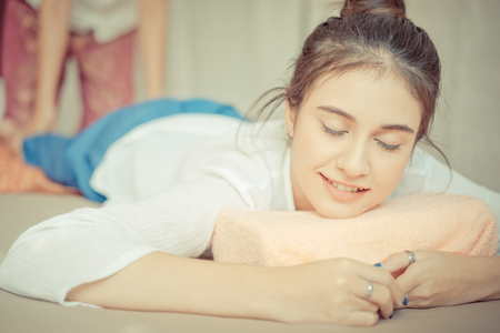 Women with closed eye smiling while taking a Thai massageの写真素材