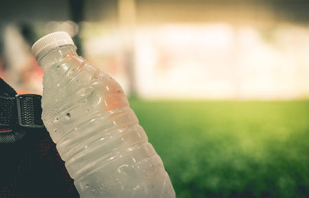 Fresh cool water bottle in soccer field copy space for sport conceptの写真素材